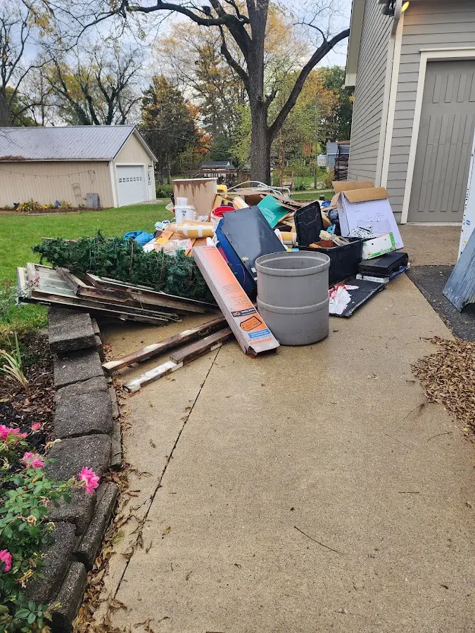 Dumpster being loaded with debris for 12 Yard Dumpster Rental in Bartlett